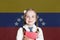 Learning spainish language. Smart child girl on the spain flag background