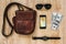 Leather bag, smartphone, sunglasses, watch, money on wooden background. Men`s accessories. Outfit of traveler, student, teenager,