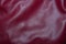 Leather burgundy background with pleats. Red Leather Texture Background