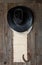 leather cowboy hat with lasso and horseshoe on rough wooden table and blank paper with place for text