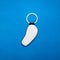 Leather key ring in curve shape on blue paper background. Blank key chain for your design