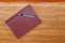 Leather notepad with pen on cherry wood desktop