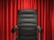 Leather office chair on red curtain background