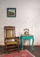 Leather rocking chair, wooden green vintage table and antique golden telephone set over bricks wall