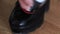 Leather shoe care. Applying shoe polish to black shoes. Shabby leather black shoes.