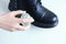 Leather shoe care. Black shoe and water repellent spray for shoes in the hands of a Caucasian woman.