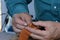 Leather work: craftsman at work creating decor on a leather product.