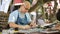 A leather worker is painting on a sheet of leather.. Tanner works with leather, makes purse, manual labor, small business, product