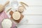 Leaven, flour, water, rolling pin, whisk and ears of wheat on white wooden table, flat lay. Space for text