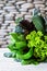 Leaves of green and red lettuce, kale, spinach, amaranth on white table with stone background