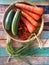 Leaves of minion, carrots, cucumber and Chilli on colour wood background