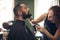 Leaving no strands out of place. a handsome young man sitting and getting his beard styled by his hairdresser.