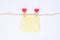 Leaving secret congrats concept. Close up photo of small yellow paper sticker hanging on a rope attached with heart shaped