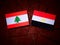 Lebanese flag with Egyptian flag on a tree stump isolated