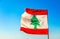 Lebanese red and white with green cedar tree flag waving on the  wind with blue sky, Byblos, Lebanon