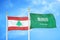 Lebanon and Saudi Arabia two flags on flagpoles and blue cloudy sky