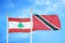 Lebanon and Trinidad and Tobago two flags on flagpoles and blue cloudy sky