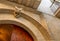 Lecce, Puglia, Italy. August 2021. Detail of a door in the historic center: a stone angel is intent on placing a crown on the arch