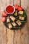 Lechon kawali or crispy deep fried pork belly served with sweet and sour sauce closeup in the slate dish. Vertical top view