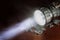 LED flashlight on a wooden table with a croak, in the smoke.