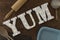 LED-Illuminated Letters Spelling YUM Surrounded by Cooking Tools