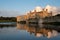 Leeds Castle near Maidstone in Kent, UK, reflected in the surrounding water, photographed on a crisp, clear day in autumn.