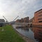 the leeds lock entrance to clarence dock with footbridge over the river aire and lock gates and mooring area surrounded by modern