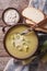 Leek cream soup in bowl close-up on the table. Vertical top view