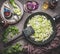 Leeks dishes cooking preparation. Steamed leeks in frying pan on rustic kitchen table background, top view. Healthy vegetarian f