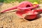 Left children toys on the sand. Red watering can, shovel and yellow ball.