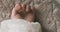 A left hand of sleeping asian baby on the carpet handheld