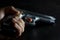 Left human hand holding gun. 9 mm parabellum semi automatic stainless steel pistol lay down on low light dark background