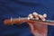 Left musician hand clamps the chord on the ukulele, top view