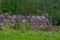 Leftovers of stone block building in summer green meadow