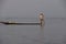 Leg rowing fisherman sets his nets