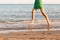 Leg of woman running on beach with water splashing. summer vacation. legs of a girl walking in water on sunset