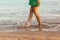 Leg of woman running on beach with water splashing. summer vacation. legs of a girl walking in water on sunset