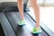 Leg of woman running on treadmill in the gym which runner athletic by running shoes. Health and sport concept background