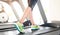 Leg of woman running on treadmill in the gym which runner athletic by running shoes. Health and sport concept background