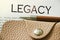 Legacy word, beige leather wallet and pen. Last will heritage statement wellfare concept