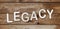 Legacy word formed from white alphabetic letters on wooden background. Law concept