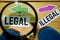 Legal or Illegal opposite direction signs in magnifying with sneakers and compass on wooden