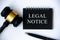 Legal notice text on black notepad with gavel and pen on white background. legal and law concept