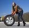 Leggy beautiful female holds big wheel