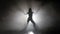 Leggy girl dancing in a smoky studio rhythmic dance. Silhouette