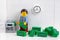 Lego businessperson minifigure putting money into a safe that is in his office