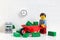 Lego businessperson minifigure transporting money in a wheelbarrow