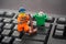 Lego minifigure cleaning keyboard with a broom