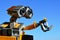 LEGO Wall-E robot from Disney Pixar movie is watching two LEGO Minecraft bees sitting on his left arm, spring clear blue skies