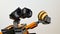 LEGO Wall-E robot examining bivalve seashell of Cockle family, possibly Cerastoderma Edule, in his left arm, light grey background